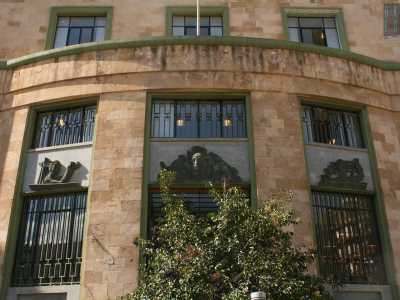 Tutto nel palazzo rimanda al mondo della posta. Se ci spostiamo ad esempio sul prospetto laterale, quello che si affaccia su piazza Cesare Battisti, notiamo tre altorilievi in bronzo ritraenti la Posta, le Comunicazioni e il Telegrafo 